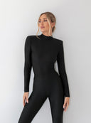 Modelka w czarnym body Louisa z zabudowanym dekoltem i poduszkami na ramionach
