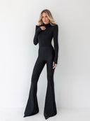 Sylwetka ujęta pod kątem w czarnych dzwonach Elvora oraz eleganckiej bluzce
